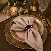 A 2.3-inch eggplant napkin ring holding a beige napkin on a table setting - thumbnail number 4