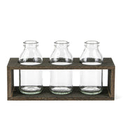 Three vintage milk bottle vases sitting in a rustic wooden stand - thumbnail number 1