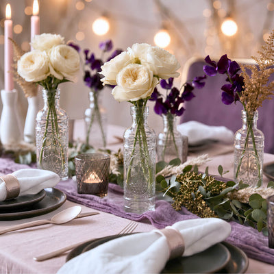 Bud vases featuring floral arrangements on a lavender runner and greenery - thumbnail number 4