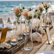 Tall glass bud vases with flowers, air plants, and seashells on a beach wedding table - thumbnail number 5
