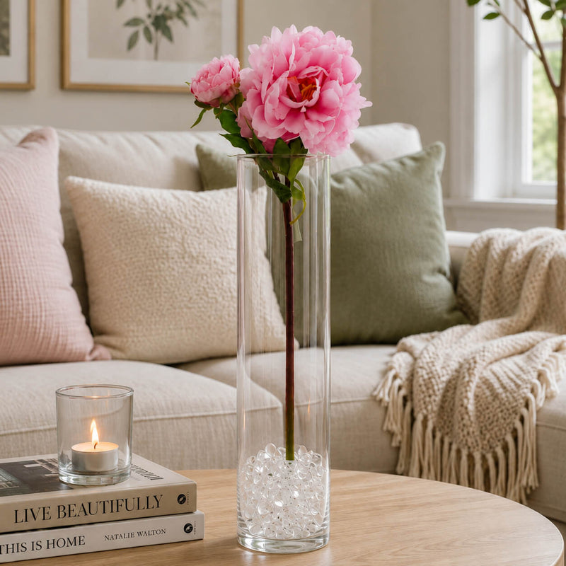 A 22-inch pink peony spray in a tall glass vase filled with clear beads on a coffee table - thumbnail number 7