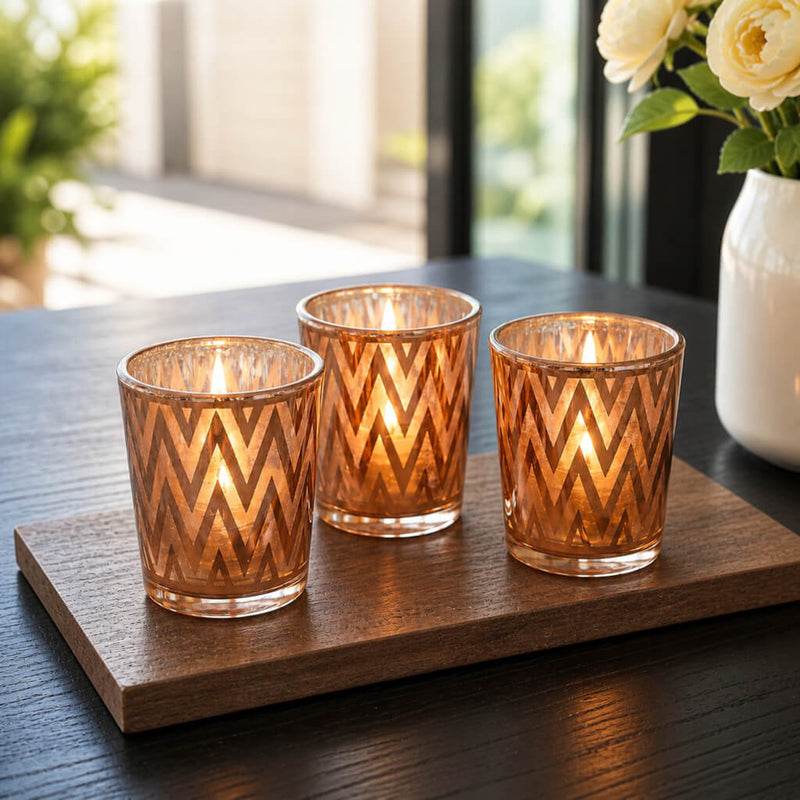 Three rose gold chevron votive holders with glowing candles on wood tray - thumbnail number 8