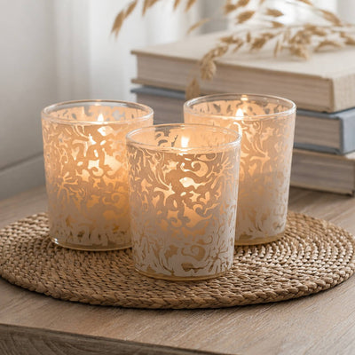 White lace design votive candle holders glowing on rustic wooden table decor - thumbnail number 8