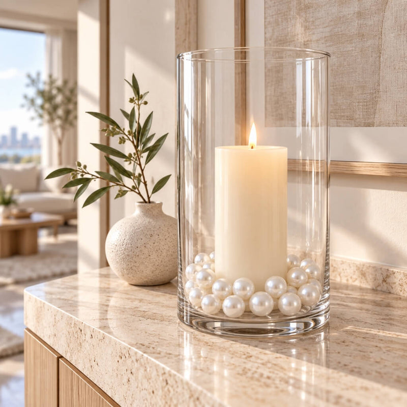 Glass cylinder vase filled with faux pearls and a lit candle on a table - thumbnail number 11