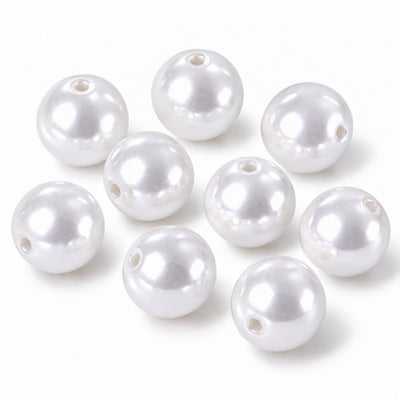 Several glossy white faux pearl craft beads with center holes arranged on a white surface - thumbnail number 1