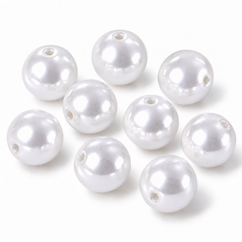 Several glossy white faux pearl craft beads with center holes arranged on a white surface - thumbnail number 1