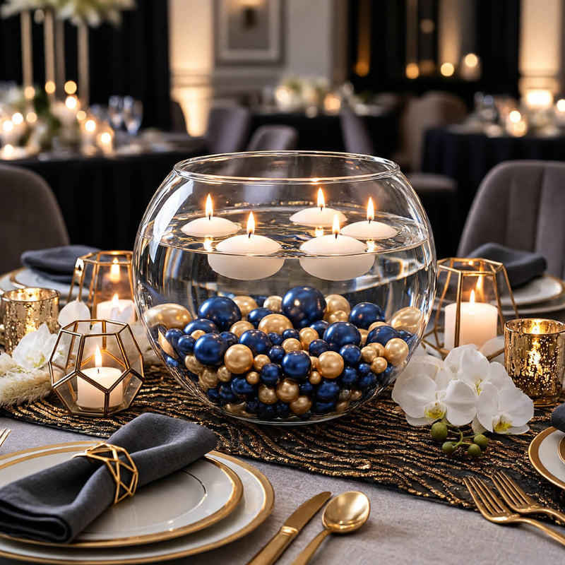 A large glass bowl filled with navy blue and gold pearls topped with floating candles on a table - thumbnail number 5