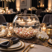 Floating candles in a glass bowl filled with rose gold and off-white pearls on an elegant table - thumbnail number 5