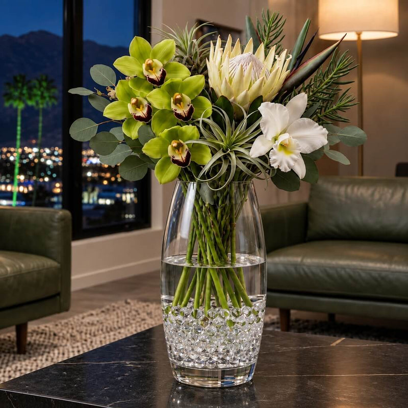 A tall glass vase with flowers sitting on a table, filled with clear water gel beads - thumbnail number 8