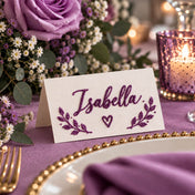Place card with the name Isabella written in purple glitter, surrounded by floral decor - thumbnail number 2