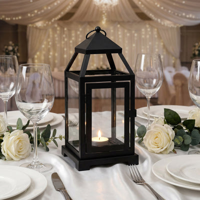 Black metal candle lantern with glowing tealight surrounded by white roses and table settings - thumbnail number 3