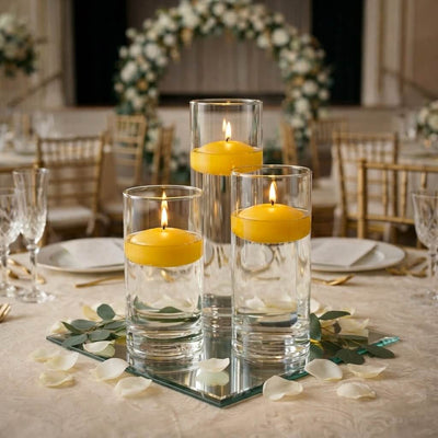 Three floating candles in glass cylinders on a wedding table with flower petals - thumbnail number 6