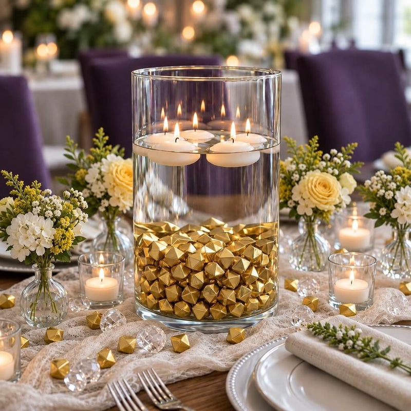 Tall glass cylinder filled with gold acrylic ice beads and floating candles on a wedding table - thumbnail number 4