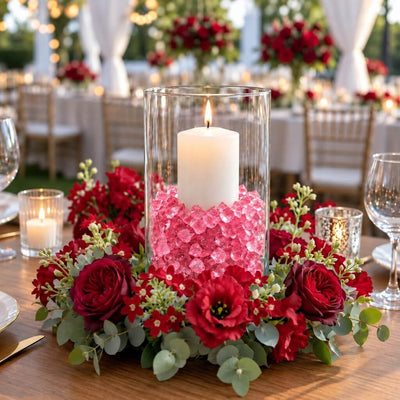 Lit white candle in a glass cylinder with pink acrylic ice beads surrounded by a red rose wreath - thumbnail number 2