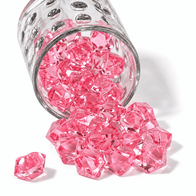 Pink acrylic ice beads spilling out of a textured clear glass jar onto a white background - thumbnail number 1