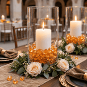 Orange acrylic ice beads fill glass vases around lit candles and flowers - thumbnail number 4