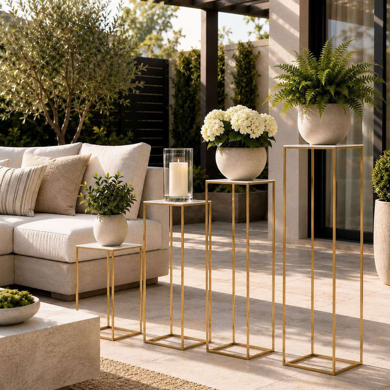 Four gold metal stands with white acrylic tops displaying plants and a candle on a patio - thumbnail number 9