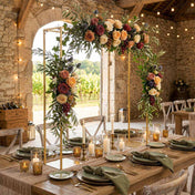 Gold metal arch stand over a rustic wedding table, decorated with rich floral arrangements and candles - thumbnail number 6