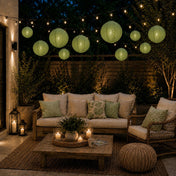 Sage green hanging paper lanterns suspended over a cozy, candlelit outdoor patio lounge - thumbnail number 6