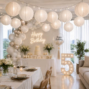 White paper lanterns hanging as decoration above a birthday party table setup - thumbnail number 2