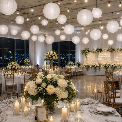 Set of 8 white paper lanterns in various sizes hanging over a wedding reception dining area - thumbnail number 3