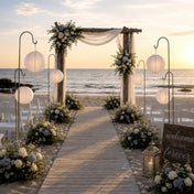 White paper lanterns hanging on shepherd hooks at a beach wedding ceremony - thumbnail number 4