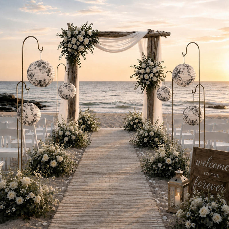 Black and white French toile paper lanterns hanging on shepherd hooks at a beach wedding ceremony - thumbnail number 4