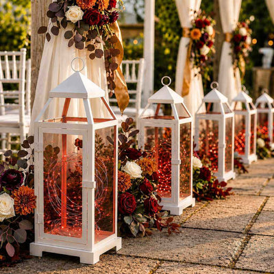 White lanterns with red LED fairy lights placed along an aisle with flowers - thumbnail number 4