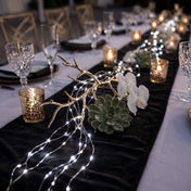 White LED fairy lights draped over a decorative branch on a formal table centerpiece - thumbnail number 5