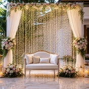 Warm white LED curtain lights as a wedding backdrop behind a sofa with floral arrangements - thumbnail number 3