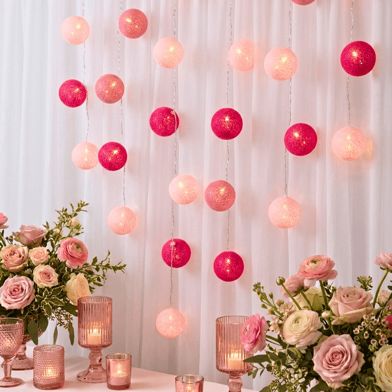 Pink and fuchsia LED cotton ball string lights hanging as a vertical backdrop behind flower bouquets - thumbnail number 6