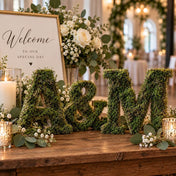 Letters spelling "A&M" covered in preserved green reindeer moss as part of a wedding decor display - thumbnail number 4