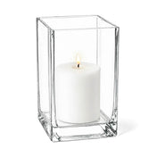 Warm candle flame glowing from within a glass Square Pillar Candle Holder 6" on white - thumbnail number 3