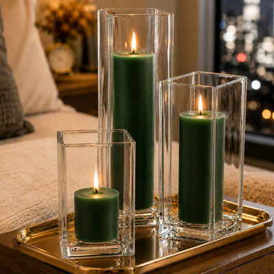 Three lit dark green candle and square holder sets arranged on a gold tray with a city backdrop - thumbnail number 7