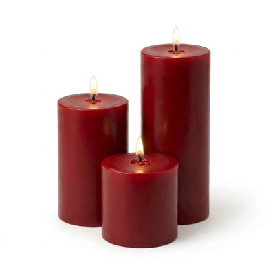 Three lit red pillar candles in assorted sizes on a white backdrop - thumbnail number 2