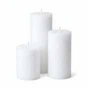 Three unlit white pillar candles in assorted sizes on a white background - thumbnail number 1
