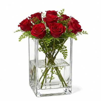 Clear 6" square vase filled with water, green foliage, and red roses - thumbnail number 6