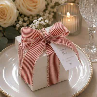 White gift box tied with red and white striped linen ribbon and a Thank You tag on a plate - thumbnail number 4