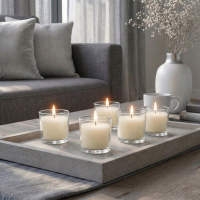 Lit white candles in glass votives on a concrete tray in a living room - thumbnail number 7