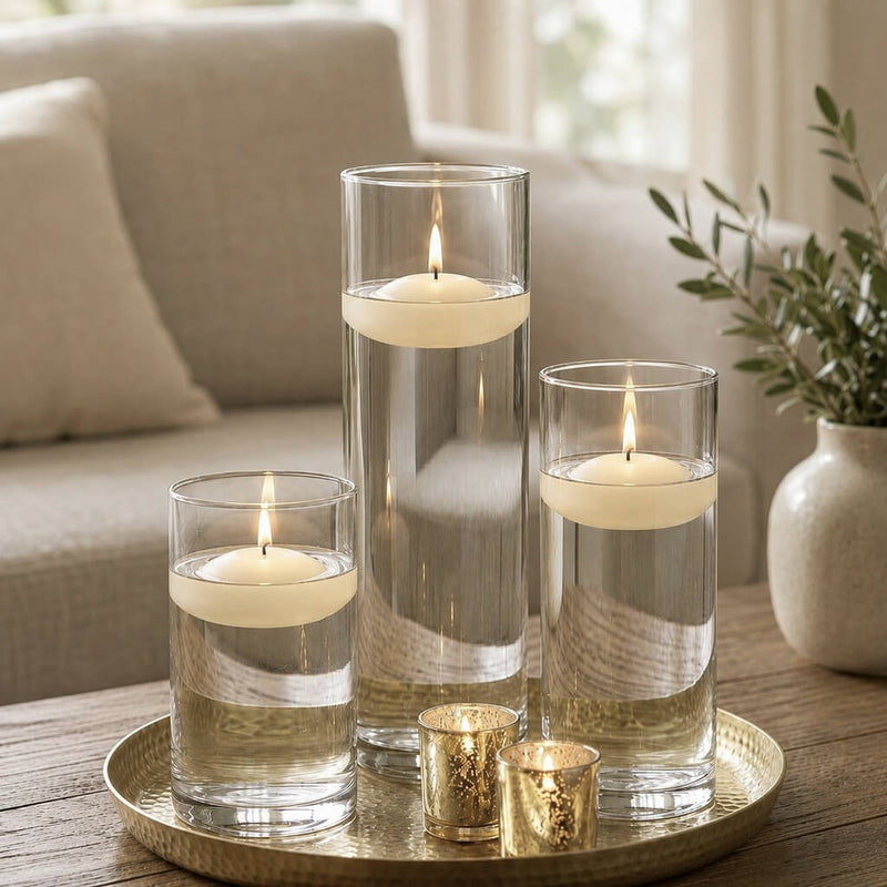 Three lit light ivory floating candles in cylinder vases and two gold votives on a tray - thumbnail number 6