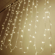 Warm white LED curtain lights hanging in vertical strands against a plain wall - thumbnail number 1