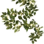 Vibrant greenery garland with warm string lights on white background - thumbnail number 1
