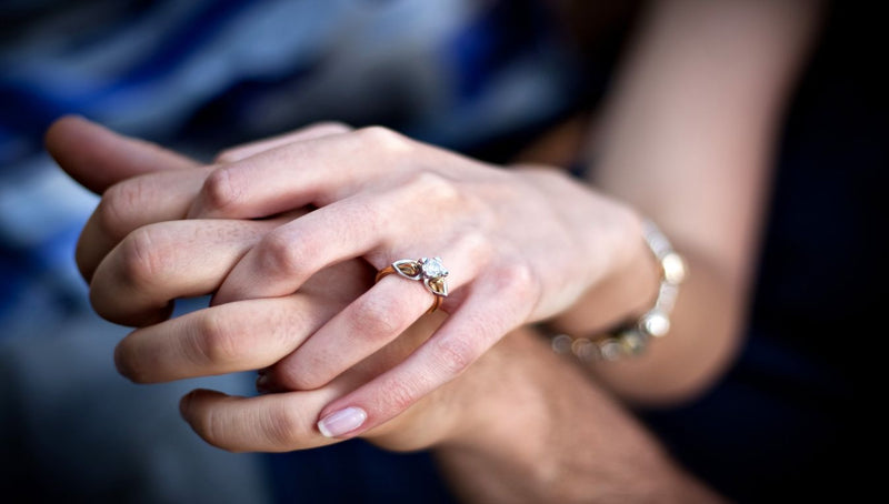 couple holding hands close up.