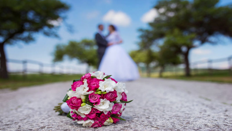 bouquet with bride and groom in the background