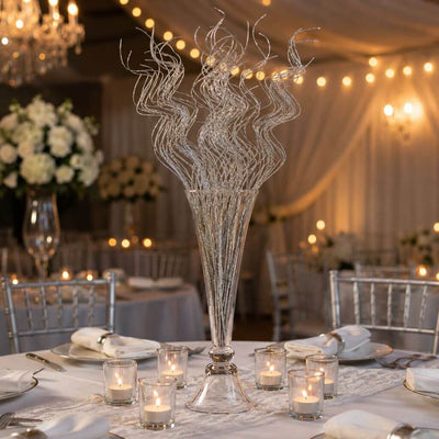 Silver sparkle curly ting stems in a glass vase on a wedding reception table - thumbnail number 4