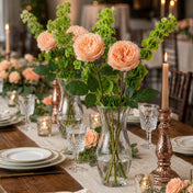 Peach garden roses in a glass vase on a rustic dining table setup - thumbnail number 2