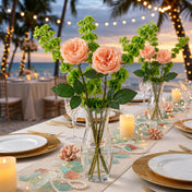 Peach roses and green fillers in a glass vase on a beach wedding table - thumbnail number 5