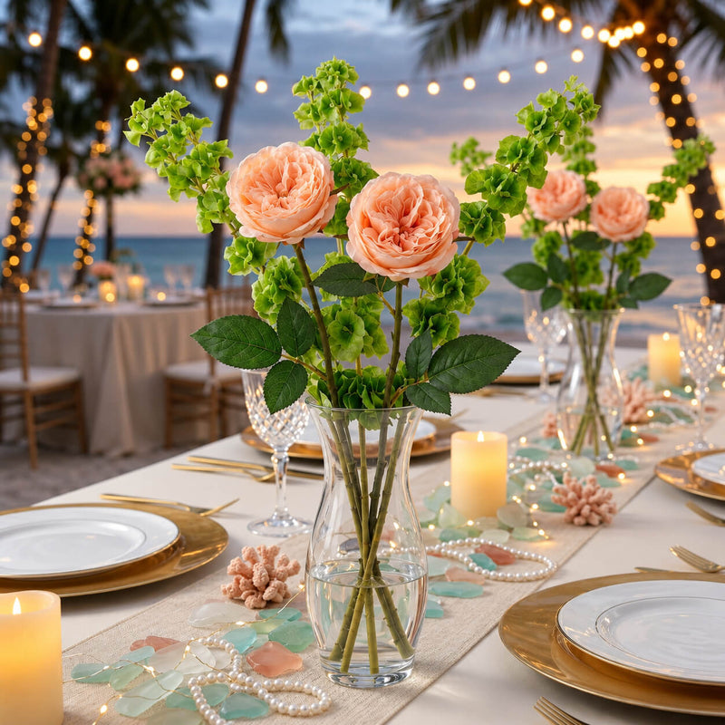 Peach roses and green fillers in a glass vase on a beach wedding table - thumbnail number 5
