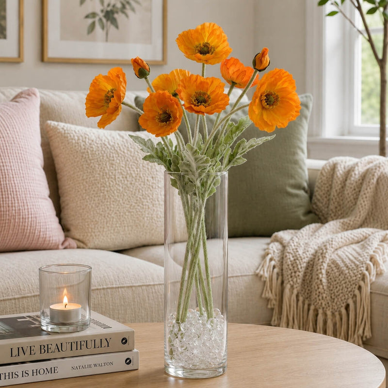 Orange poppy flower sprays in a tall glass vase on a coffee table with books and a candle - thumbnail number 8