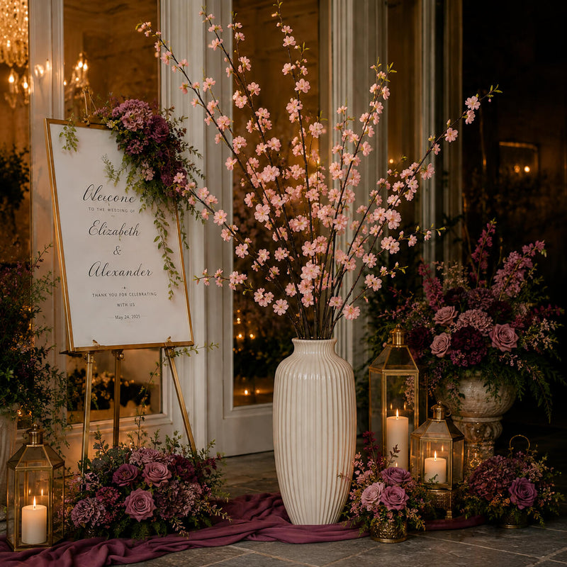 Tall white vase filled with pink cherry blossom branches next to a wedding sign - thumbnail number 3